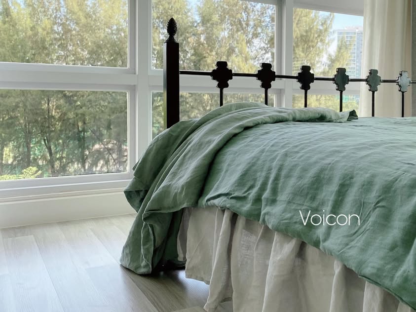 Cottage style bedroom with sage green linen duvet on wrought iron bed and tree view - SCANDALINEN