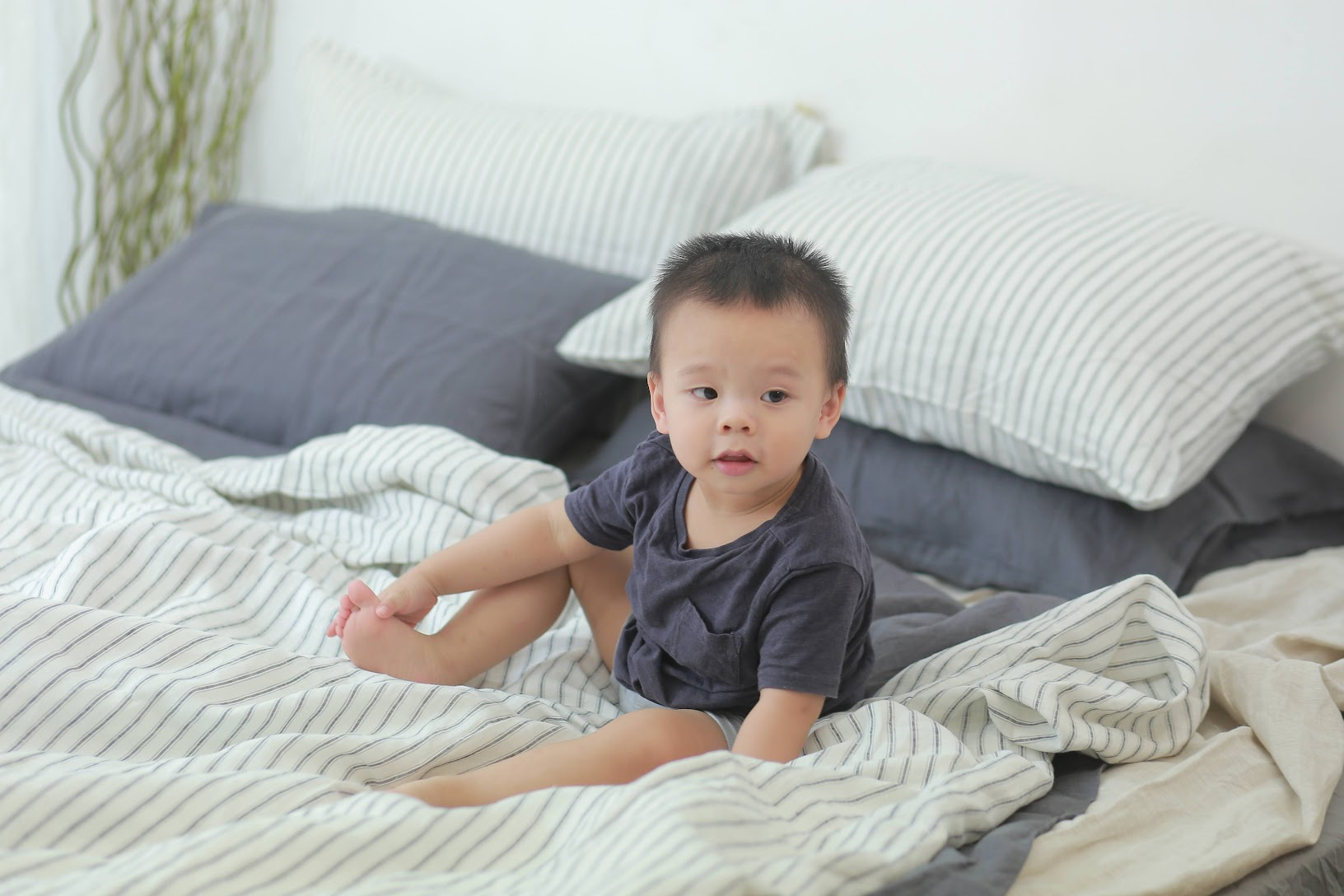 Baby sitting on French linen sheets — soft, hypoallergenic linen bedding safe for sensitive skin
