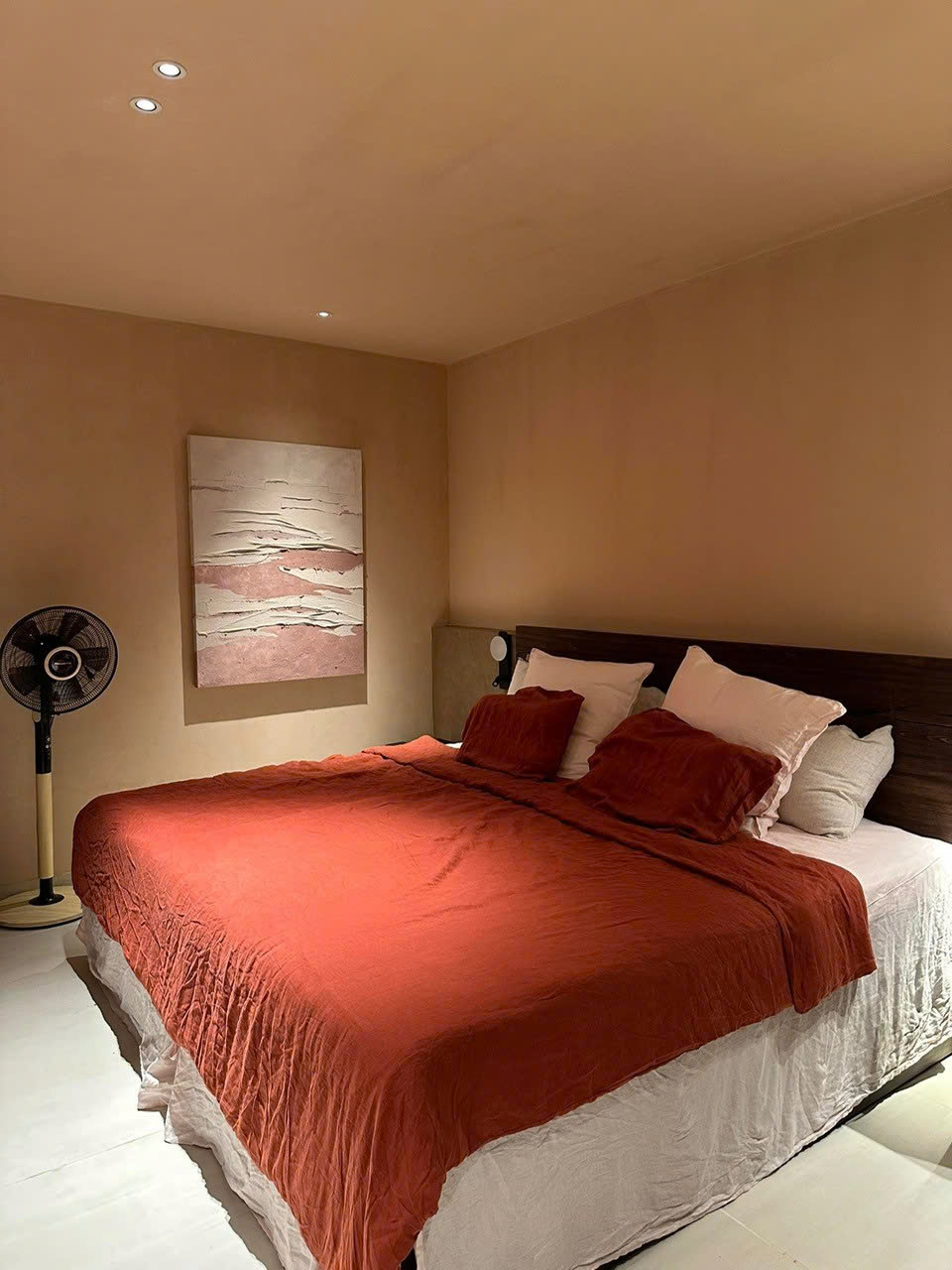 Warm minimalist bedroom with rust red linen duvet over white fitted sheet - SCANDALINEN