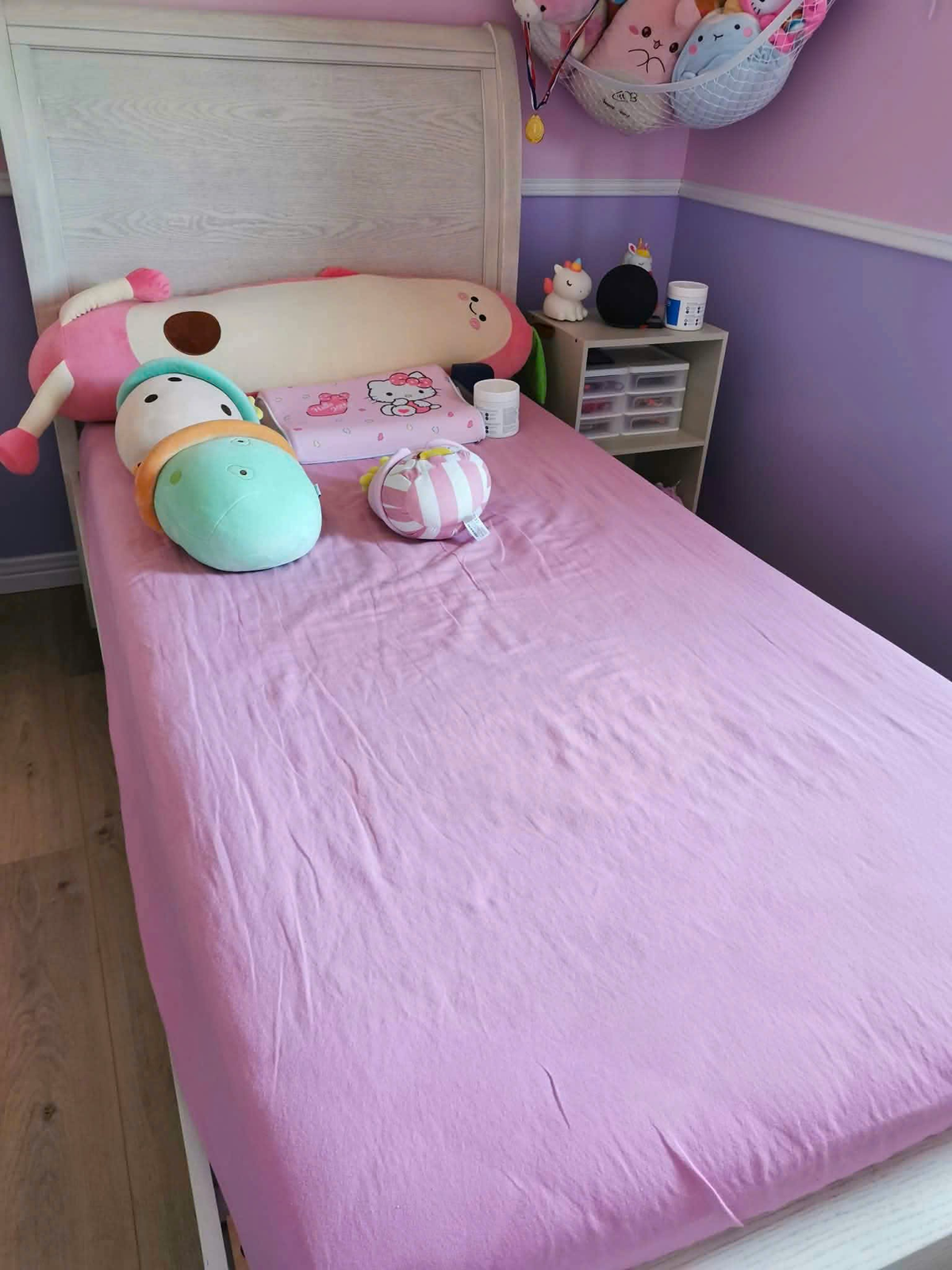 Real kids' bedroom with pink bedding, soft toys and playful decor