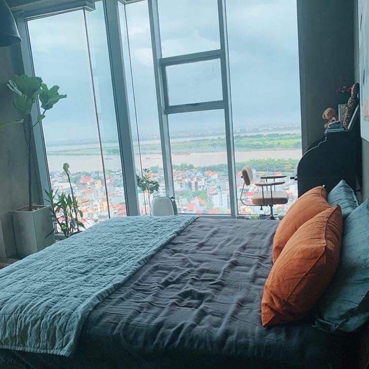 Slate blue SCANDALINEN French linen bedding in a high-rise bedroom with panoramic city view