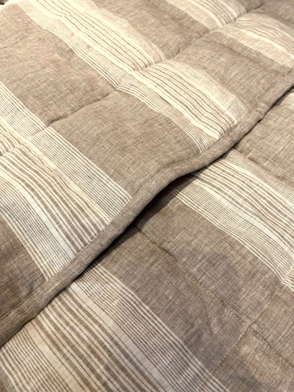 Natural oat stripe French linen quilted blanket on a bed, 100% European flax - SCANDALINEN